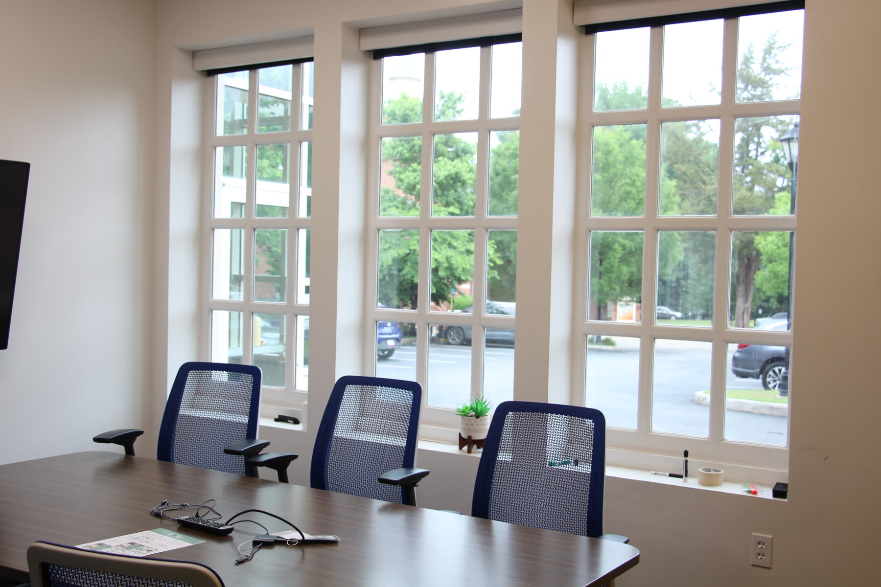 Conference room at the William and Mary Entrepreneurship Hub, three tall windows and an empty sill, photographed before any plants were installed